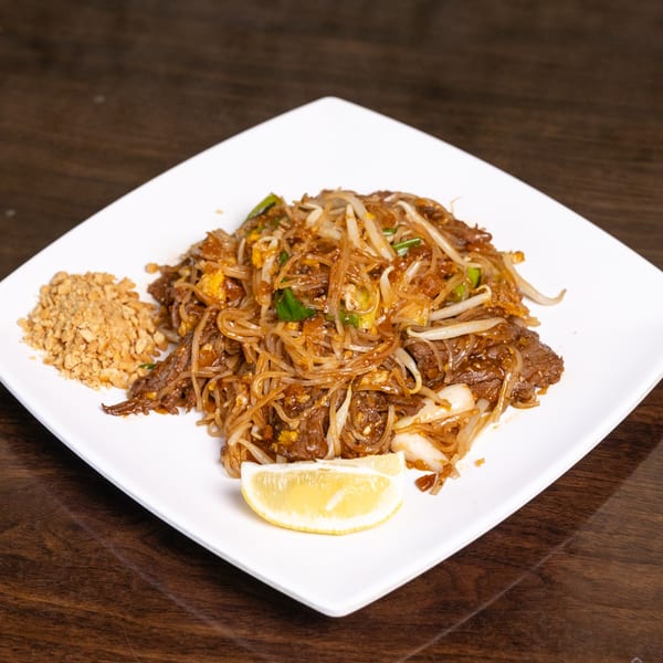 Thai Palace MD's Pad See Ew with beef, noodles, bean sprouts, and a lemon wedge.