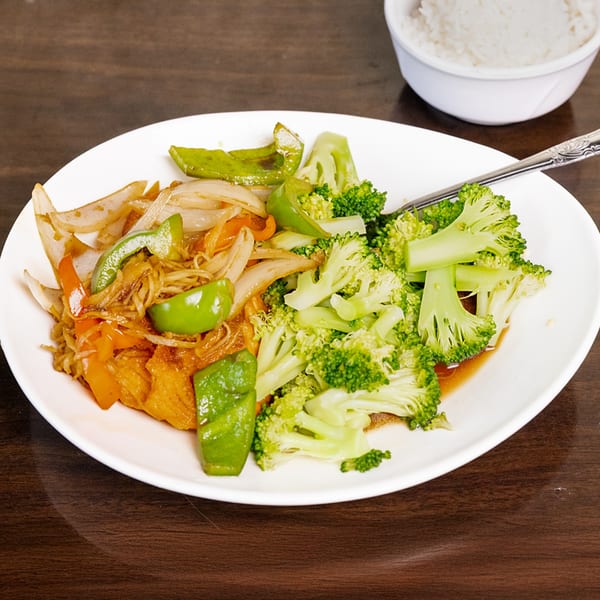 Thai Palace MD's stir-fried vegetables with broccoli, onions, and bell peppers, served with rice.